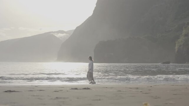 Carefree woman playing by water in Seixal, Madeira, Portugal, wide shot (SLOG3)