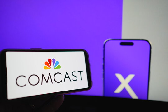 Roosendaal, The Netherlands - August 02, 2025: A mobile phone displaying the company logo of Comcast, with the company website in the background.