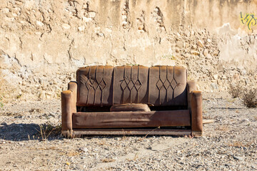 an old brown sofa in the outdoors against a brown background
