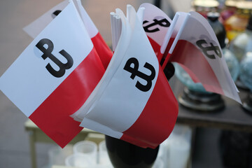 Polish flags with the Kotwica symbol, representing the Warsaw Uprising, displayed together for patriotic or memorial occasions. © olga
