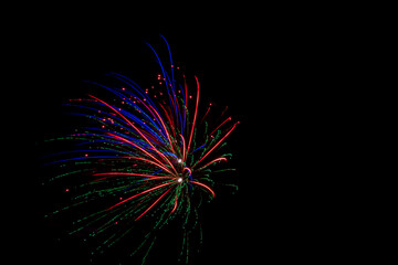 Colorful fireworks illuminate the dark night sky, creating vibrant displays of light and festive...