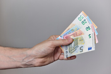 Hand Holding Euro Banknotes on Neutral Background