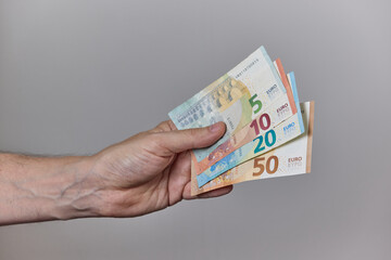 Hand Holding Euro Banknotes on Neutral Background