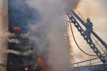 Firefighter extinguishing blaze at grain elevator © Vladyslav 