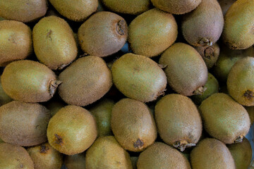 Lots of ripe kiwis. Kiwis in a box. Kiwis for sale at the market and in the store. Background. Top...