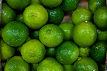 Lots of green lime. Lime in a box. Sale of lime at the market and store. Background. Top view....