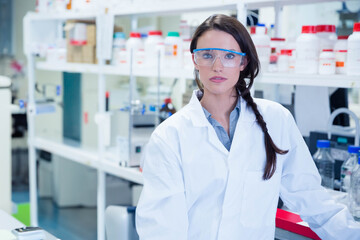 Reagent bottles with red green blue caps are sitting on white bench in laboratory beside glassware