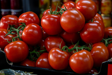 Many ripe red tomatoes. Cherry tomatoes. Pink tomatoes. Tomatoes in a box. Sale of tomatoes at the...