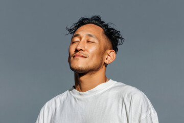 Obraz premium Relaxed Asian Man Exhaling Gently – Mindfulness Campaign Banner