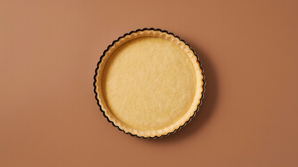 Empty tart shell with a detailed, crimped edge sits centered on a warm-toned background.