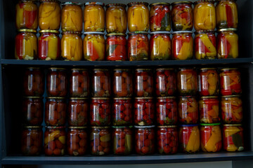 Canned vegetables in jars stand on the shelf. Background. Top view. Concentration of canning for...