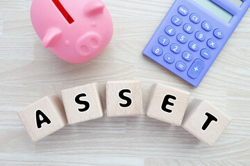ASSETと貯金箱と電卓。資産管理と貯蓄のイメージ。