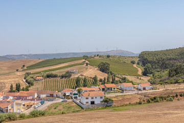 Fototapeta premium Rolling Hills and Rural Village in Summer Light