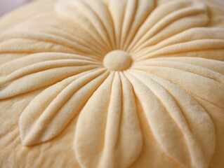 Plush circular floral petal cushion pastel yellow tone close up focus soft fabric details