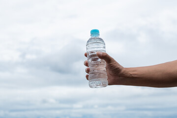 水のペットボトルを持っている人	