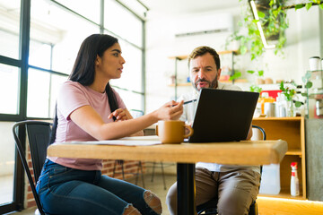 Hispanic freelancers working on a project in a coffee shop