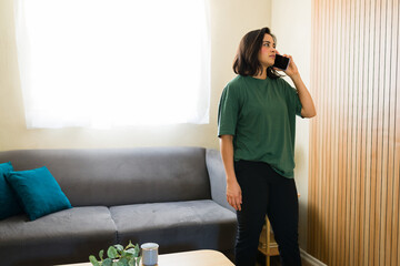 Hispanic freelancer working from home talking on phone