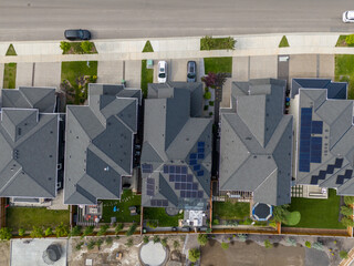 Looking down on new suburban homes with solar panels installed on the roof.