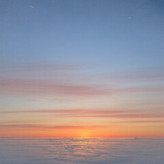 Fototapeta premium Sunrise over a sea of clouds with pink and orange hues