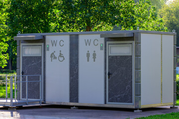 Modern public WC toilet facility in a city park with separate sections for men, women, people with...
