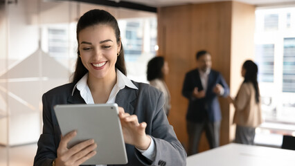 Plakat Technology for modern business. Cheerful confident young businesswoman finance advisor personal assistant manager consultant networking with client in chat using digital pad browse information online