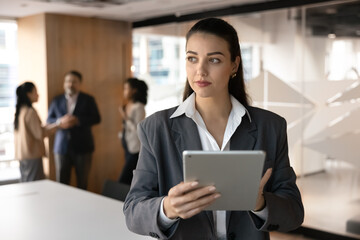 Solving workplace challenge. Pensive young businesswoman project manager ceo analyst stand at...
