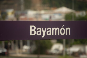 Fototapeta premium Letrero con la palabra “Bayamón” en una estación del Tren Urbano en Bayamón, Puerto Rico. La imagen destaca el sistema de transporte público y la identidad urbana de la ciudad.