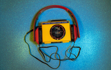 A cassette player from the Sports line in bright orange, red headphones, and several cassettes...