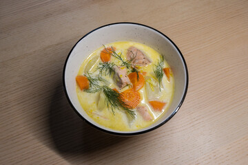 A bowl of salmon and vegetable soup.