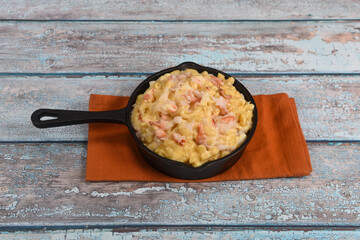 A mini cast iron skillet full of delicious creamy lobster mac and cheese.