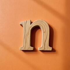Lowercase Letter n Carved from Weathered Cedar Wood – Rustic Design with Soft Grain Texture on Warm Soft Orange Background for Natural Alphabet and Organic Typography Themes