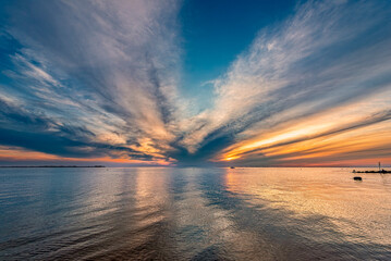 Sonnenunter- oder aufgang über dem norddeutschen Wattenmeer bei Flut oder Hochwasser am Strand von...
