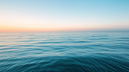Obraz premium Tranquil ocean with gentle waves under colorful sunrise sky, peaceful sea horizon with natural morning light, perfect for nature themes and travel backgrounds 