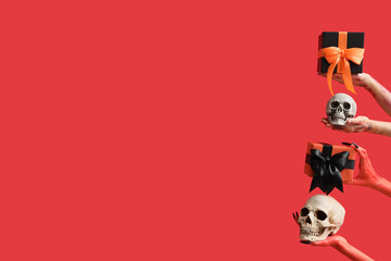 Zombie and devil hands holding gift boxes and skulls on red background. Halloween celebration