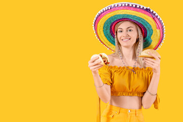 Young woman in sombrero hat with tasty tacos on yellow background