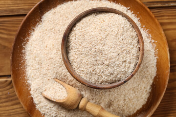 Bowl with psyllium husk powder on wooden background