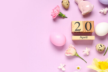 Wooden cube calendar with date 20 April, Easter eggs and beautiful spring flowers on lilac...
