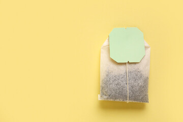 Tea bag on yellow background, closeup