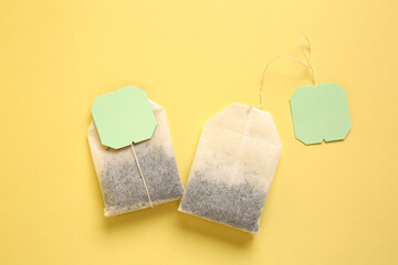 Tea bags on yellow background, closeup