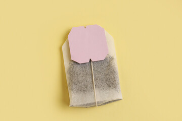 Tea bag on yellow background, closeup