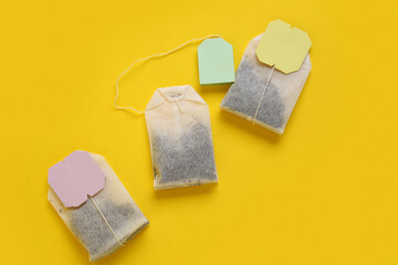 Composition with different tea bags on yellow background, closeup