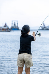a woman fishing on the beach