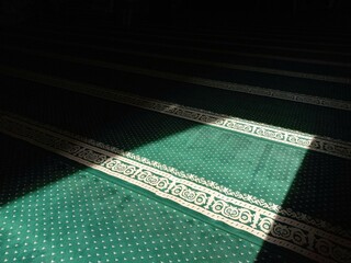 A beam of sunlight came through the open door and fell on the green carpet