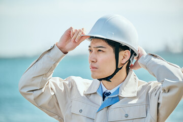 ヘルメットをかぶる作業服姿の男性