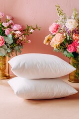 Two white pillows rest on a light pink surface, surrounded by bouquets of pastel-colored flowers in various vases