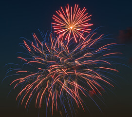 Vibrant red and blue fireworks explode against the night sky, creating a festive burst of color and light. Perfect for New Year&rsquo;s Eve, Independence Day, or holiday celebrations.