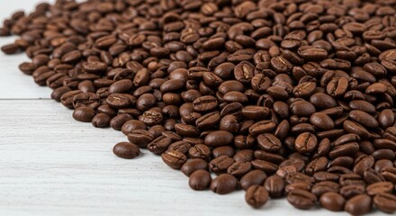 Obraz premium Pile of aromatic roasted coffee beans on white wood for a fresh caffeine boost