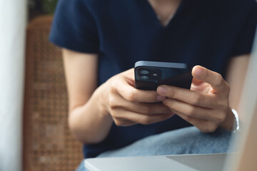 Woman using smartphone and laptop for online shopping and internet payment at home. Searching internet social networks or remote working at coffee shop, business casual, closeup
