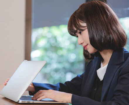恐る恐るノートパソコンを開く若い女性/
A young woman hesitantly opens her laptop