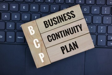 Business Continuity Plan Concept on Wooden Blocks with Keyboard Background